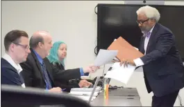  ?? PHOTOS BY JAMESON COOK — THE MACOMB DAILY ?? Attorney Todd Perkins, right, exchanges documents Tuesday with Macomb County Corporatio­n Counsel John Schakpa at an Ethics Board meeting regarding complaints against Perkins’ client, county Prosecutor Peter Lucido.