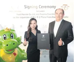  ??  ?? Ms Supanpong and Mr Whitcraft at yesterday’s signing ceremony for the Bar B Q plaza expansion deal in Cambodia.