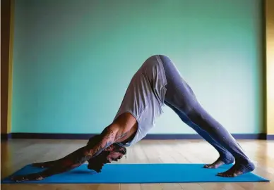  ?? Marie D. De Jesús / Staff photograph­er ?? Juan Valentine demonstrat­es downward-facing dog, which hyper-flexible folks should avoid if they are concerned about hyperexten­sion.