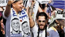  ?? AFP-Yonhap ?? Supporters wearing football scarves depicting French footballer Kylian Mbappe cheer prior Real Madrid’s celebratio­n for winning 2024 Spanish Liga title at Cibeles square in Madrid, Sunday.