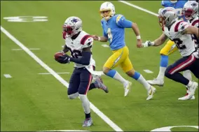  ?? ASHLEY LANDIS - THE ASSOCIATED PRESS ?? New England Patriots’ Devin McCourty, left, returns a blocked field goal for a touchdown during the first half of an NFL football game against the Los Angeles Chargers Sunday, Dec. 6, 2020, in Inglewood, Calif.