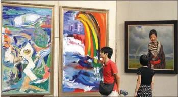  ??  ?? Visitors admire works of art during an Olympic-themed exhibition in Xiamen, Fujian province, on Thursday. The exhibition is a sideline event of the 17th China Internatio­nal Fair for Investment and Trade.