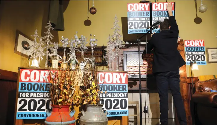  ?? (Reuters) ?? A CORY Booker supporter puts up a placard.