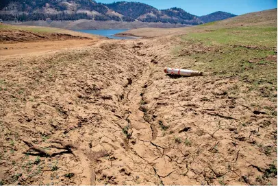  ?? BRIAN VAN DER BRUG/LOS ANGELES TIMES/TNS ?? In June, in Oroville, Calif., a stranded buoy sits on the dried mud of the lake bed of Lake Oroville which stands at 33%.