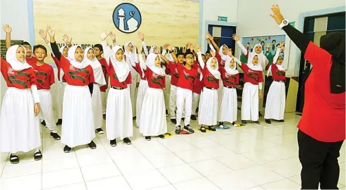  ?? ALLEX QOMARULLA/JAWA POS ?? SETELAH KOMPETISI KETIGA: Tim Al-Azhar 35 Primary School Choir unjuk kebolehan di lobi gedung sekolah. Mereka menyabet medali perak di Bali Internatio­nal Choir Festival 2018.