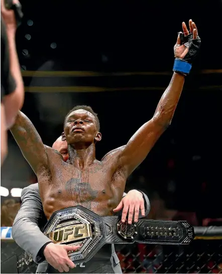  ?? AP ?? Israel Adesanya gets the title belt wrapped around him after his win in Atlanta yesterday.