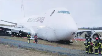  ??  ?? A SkyLease Cargo plane skidded off a runway at Halifax Stanfield Internatio­nal Airport and stopped near a road on Wednesday. The airport suspended flights after the incident.
