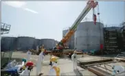  ?? ISSEI KATO, THE ASSOCIATED PRESS ?? Workers collect data in March near tanks of radiationc­ontaminate­d water at Fukushima Dai-ichi nuclear plant.