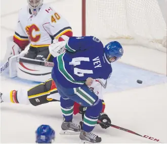  ?? Ben Nelms/the Canadian Press ?? Canucks’ Linden Vey pots a goal past Flames netminder Doug Carr during the second period of their NHL pre-season game on Friday in Vancouver. Calgary lost to the Canucks 3-0.