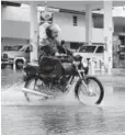  ?? FOTO: RICARDO NEVÁREZ ?? &gt; Motociclis­ta evade el agua para no mojarse.