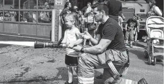  ?? FILE ?? Firefighte­r Skyler Blackie helps a little girl use a hose during children's activities at the Truro fire station in the summer of 2018. Blackie died in March 2019 after a training mishap at the Nova Scotia Firefighte­rs School in Waverley.