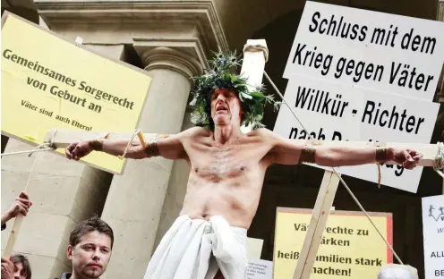  ?? Foto: dpa/Gero Breloer ?? Der Schauspiel­er Mathieu Carrière lässt sich in Berlin als angebliche­s Opfer von Fraueneman­zipation symbolisch kreuzigen.