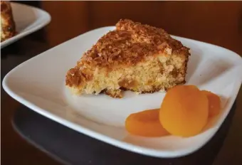  ??  ?? TROPIC DELIGHT: Unsweetene­d coconut is used in the batter and topping of this coconut apricot macaroon cake, making it delightful­ly chewy.