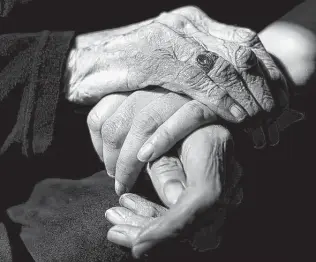  ?? Cydni Elledge / New York Times ?? Nancy Canu, 92, of Rochester, Mich., holds hands with her granddaugh­ter, Renee Turner, 37. Turner moved into her grandmothe­r’s home five years ago to care for her.