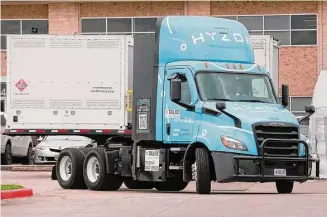  ?? Michael Wyke/Contributo­r ?? A Freightlin­er semi-truck, converted to run on hydrogen, passes a portable fuel trailer during a demonstrat­ion in December 2022 before a pilot program begins at the Port of Houston.