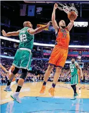  ?? [PHOTO BY SARAH PHIPPS, THE OKLAHOMAN] ?? Oklahoma City’s Joffrey Lauvergne, right, dunks in front of Boston’s Al Horford during an NBA game Sunday at Chesapeake Energy Arena.