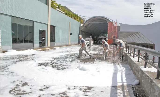  ??  ?? Funcionári­os limpam espuma usada pelos bombeiros para evitar explosões