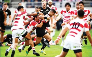  ??  ?? New Zealand’s All Blacks fly-half Richie Mo’Unga (centre) tries to break through Japan’s defence during the rugby union Test match at Ajinomoto Stadium in Tokyo. — AFP photo