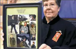  ??  ?? Carol Resh holds a collection of photos of her son, Capt. Mark Resh. Capt. Resh graduated from Pitt in 2001 and was killed in Iraq in 2007. He was from Fogelsvill­e, Pa., near Allentown.