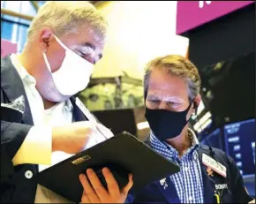  ?? ASSOCIATED PRESS ?? In this photo provided by the New York Stock Exchange, traders Edward McCarthy (left) and Robert Charmak work on the floor Friday during the Delwinds Insurance Acquisitio­n Corp. IPO.