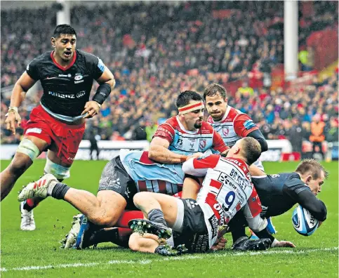  ??  ?? Stretching over: Saracens centre Nick Tompkins scores the first try of the game to silence a raucous Kingsholm crowd