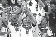  ?? MATTHIAS SCHRADER / The Associated Press ?? Germany players celebrate with the World Cup trophy after defeating Argentina 1-0 in the finals on Sunday in Brazil.