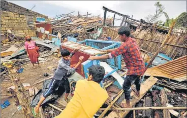  ?? REUTERS ?? People salvage their belongings from a damaged house in Navabandar village in Gujarat on Tuesday.