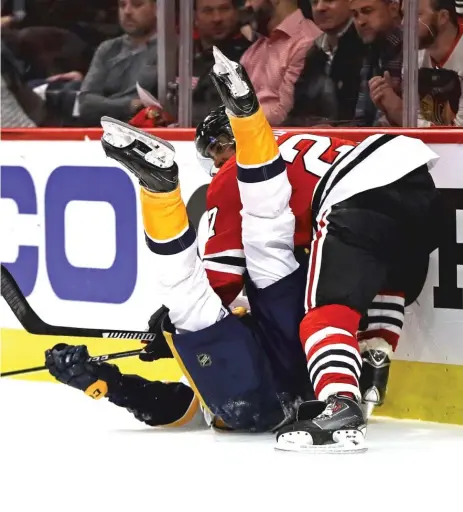  ??  ?? Hawks defenseman Johnny Oduya dumps Predators forward Filip Forsberg behind the net Thursday night in Game 1. | JONATHAN DANIEL/ GETTY IMAGES