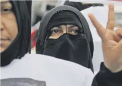  ??  ?? 0 A woman signals her support at the march yesterday