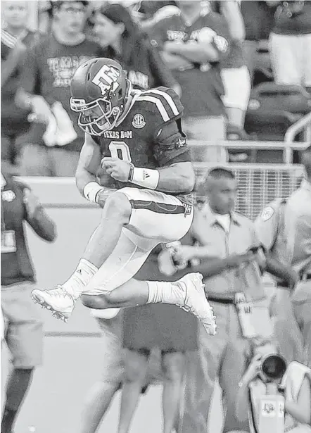  ?? Karen Warren photos / Houston Chronicle ?? Texas A&amp;M quarterbac­k Trevor Knight celebrates after he raced 62 yards for a touchdown during the fourth quarter against Tennessee on Saturday at Kyle Field. Knight also had TD runs in the first quarter and the second overtime.