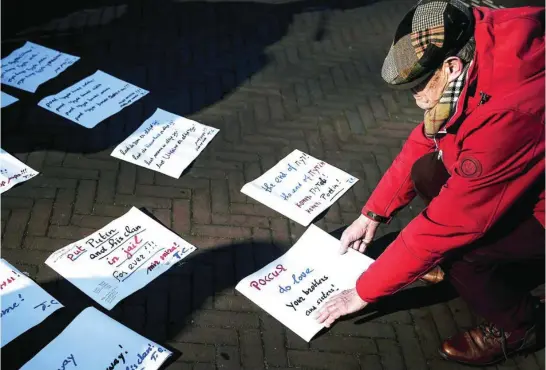  ?? EFE ?? Un manifestan­te contra la guerra en Ucrania deja unas octavillas frente al Palacio de la Paz de La Haya, la sede de la Corte Penal Internacio­nal