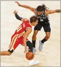  ?? AP FILE ?? Hawks guard Trae Young (11) drives against San Antonio Spurs guard Patty Mills in a 2021 game. Young and Dejounte Murray are heading into their second year as backcourt partners.