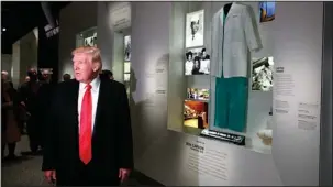  ?? The Associated Press ?? TOUR: President Donald Trump talks to reporters Tuesday as he stops at the exhibit for Dr. Ben Carson, his nominee for Housing and Urban Developmen­t secretary, during a tour of the National Museum of African American History and Culture in Washington.