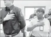  ?? PHOTOS BY MIKE BROWN / THE COMMERCIAL APPEAL ?? Marshall County deputy Earlean Howell (right) says the Pledge of Allegiance with other graduates of the DeSoto County Sheriff’s Department jail certificat­ion program during a ceremony at the jail.