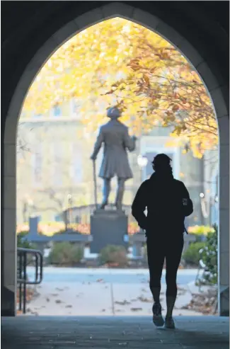  ?? MEDIANEWS GROUP FILE PHOTO ?? In this November 2014 file photo, a student makes her way through the Philips Memorial Building gateway into the Quad at West Chester University.