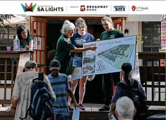  ?? Photos by Jerry Lara / Staff photograph­er ?? Catholic Worker House volunteer director Chris Plauche describes Towne Twin Village to clients. The housing community is to be built at 4711 Dietrich Road.