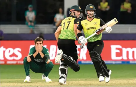  ?? — AFP photo ?? Pakistan’s Shaheen Shah Afridi (left) reacts as Marcus Stoinis (centre) and Matthew Wade run between the wickets during the ICC men’s Twenty20 World Cup semi-final match between Australia and Pakistan at the Dubai Internatio­nal Cricket Stadium in Dubai.