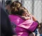  ?? KATIE MCLEAN, THE ASSOCIATED PRESS ?? A child holds onto a caretaker at Oakdale Baptist Church, following the shooting at Townville Elementary in Townville, S.C.