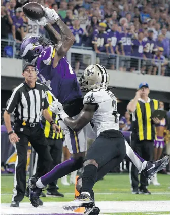  ??  ?? Vikings receiver Stefon Diggs catches a TD pass over Saints cornerback De’Vante Harris during the first half in Minneapoli­s on Monday.