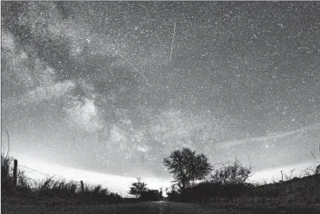  ?? Daniel Reinhardt Associated Press ?? THE LYRID meteor shower, which can be seen until about Monday, over a Baltic Sea island off Germany.