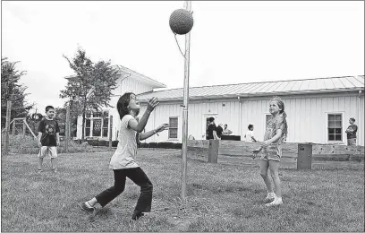  ??  ?? Fourth-grader Ma’ayan Cohen, 9, center, plays tetherball with third-graders Dovi Weiner, 7, left, and Henrietta Nathanson, 8, during recess at the Columbus Jewish Day School.