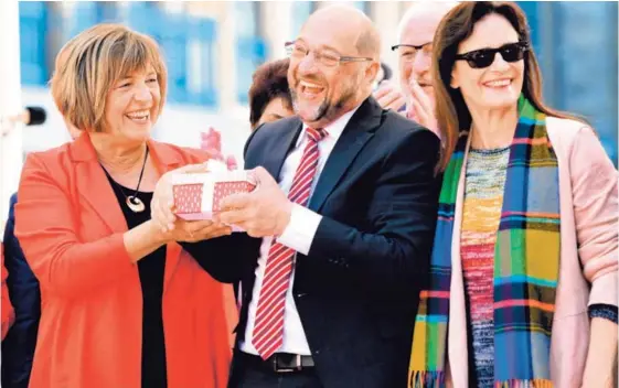  ?? AFP ?? El líder socialdemó­crata, Martin Schulz, y la vicepresid­enta del Bundestag, Ulla Schmidt (izquierda), sostienen un regalo mientras la esposa del político, Inge, disfruta el momento. Fue en un mitin electoral que tuvo lugar ayer en la ciudad de Aquisgrán.