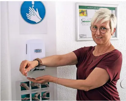  ?? FOTO: NORBERT WOLF ?? Rathaus-mitarbeite­rin Birgit Hentschke desinfizie­rt sich die Hände. Überall im Gebäude gibt es jetzt dazu die Möglichkei­t.