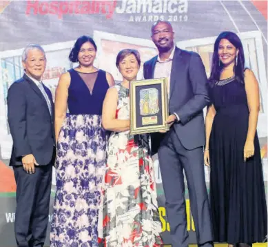  ?? ASHLEY ANGUIN ?? Rainforest Seafoods’ Everod Wilson (second right) presents the Best Business Hotel Award to The Courtleigh Hotel and Suites team (from left): Kevin Hendrickso­n, Cecile Hyatt Reynolds, Jackie Hendrickso­n and Nicola Madden-Greig.