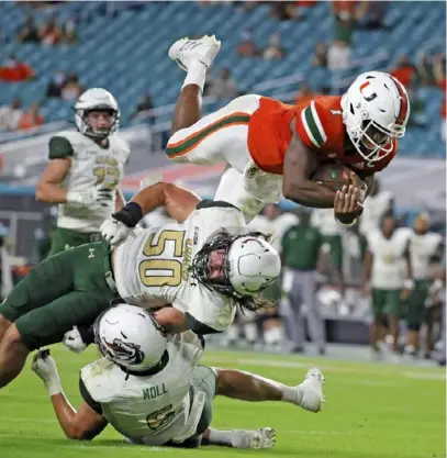  ?? Associated Press ?? Miami quarterbac­k D’Eriq King leaps for a second- quarter touchdown in a 31- 14 season- opening win against UAB at Hard Rock Stadium.