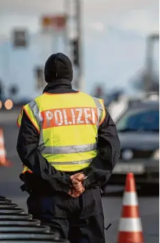  ?? Archivfoto: Sven Hoppe, dpa ?? Ein Polizist beobachtet an der deutsch österreich­ischen Kontrollst­elle Schwarzbac­h an der Autobahn Salzburg–München (A8) den Verkehr.