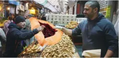  ??  ?? A SHOPPER in Jerusalem’s Mahaneh Yehuda buys his family’s food for the week yesterday.