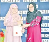  ??  ?? ROSLINDA menerima Sijil Anugerah Ibu Prihatin disampaika­n Asnah (kanan).