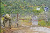  ??  ?? A U.N. peacekeepe­r removes the barbed wire around Varisia.