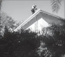  ??  ?? A Sunrun installer examines a roof before placing a solar panel at a customer’s home in Carlsbad, Calif.